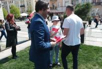 na fot.: Grzegorz Kulawinek / wiceprezydent Kalisza rozdaje flagi odwiedzającym Główny Rynek